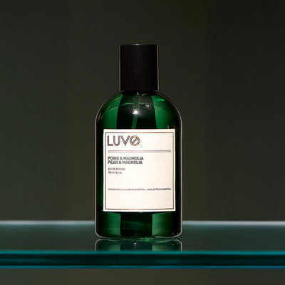 Pear & Magnolia eau de parfum 100ml in a refillable green glass bottle on a glass shelf